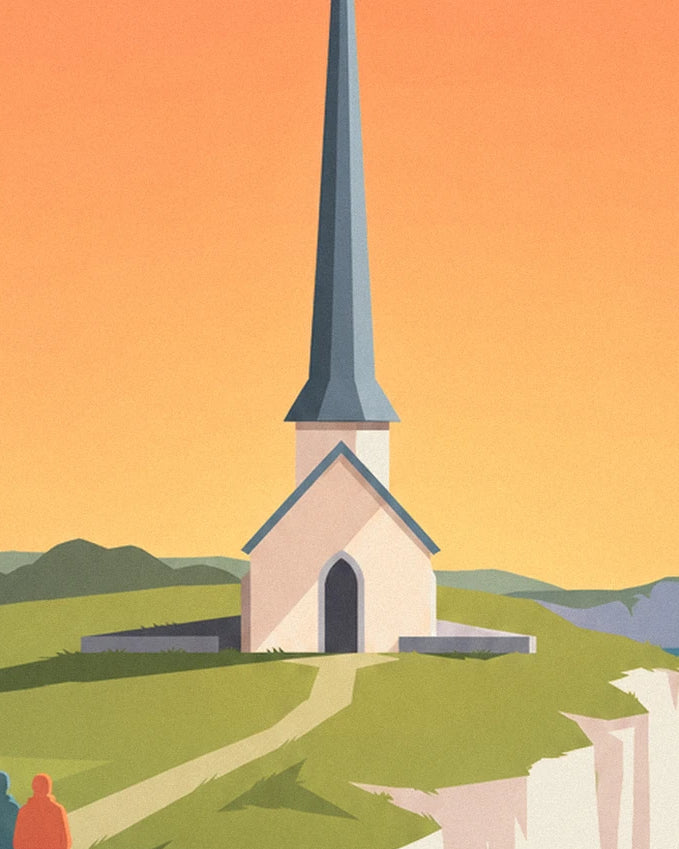 The white chapel with its pointed slate spire, on the grass against an orange sky