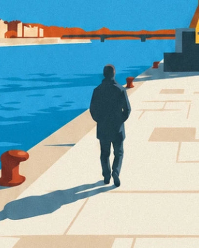 A walker seen from behind on the pale quay, between red bollards and the blue Loire