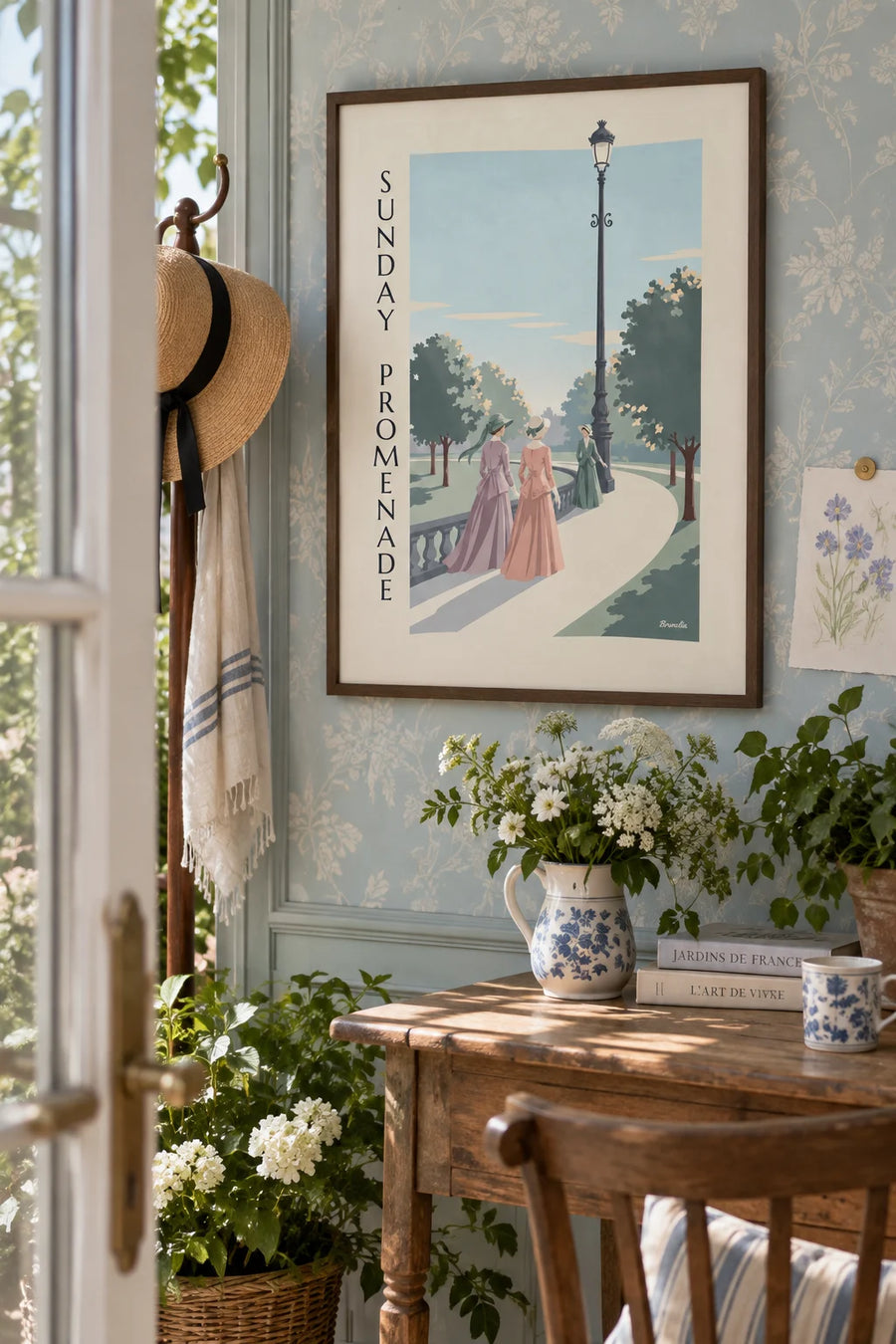 Poster of ladies in long dresses strolling in a park: framed on the wall