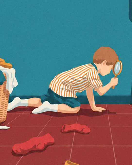 The boy kneeling with a magnifying glass, on the trail of the red socks