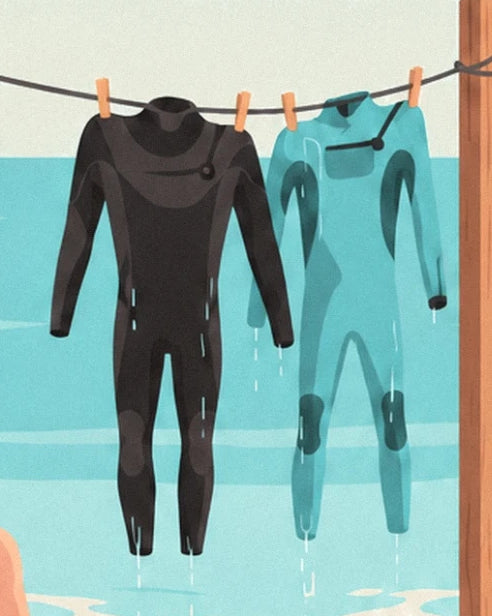 The 2 black and turquoise wetsuits hanging from clothes pegs