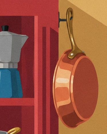 A copper frying pan with a gold handle, hanging near the red kitchen dresser and coffee pot