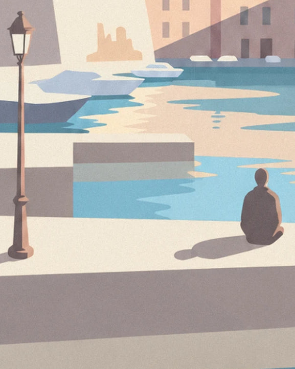 A man sitting at the edge of the quay, near a street lamp, facing the boats