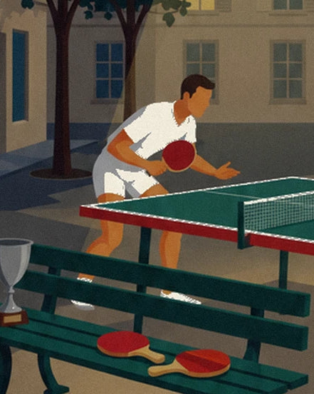 The player in white in front of the table tennis table and the 2 bats on the green bench