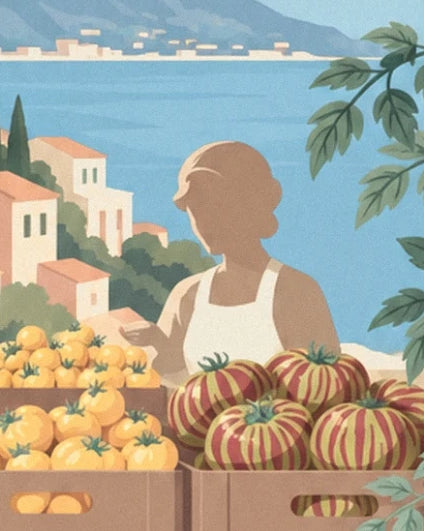 The stallholder in a white apron behind yellow and striped tomatoes, facing the sea