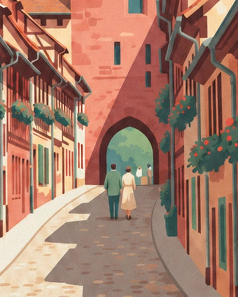 Un couple qui marche vers la porte fortifiée en grès rose, dans une ruelle pavée bordée de maisons fleuries