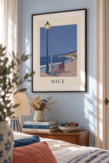 Poster of deck chairs and a street lamp facing the Baie des Anges in the evening: framed on the wall