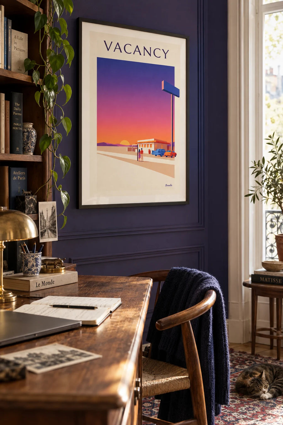 Poster of a motel neon sign beside a desert road: framed on the wall
