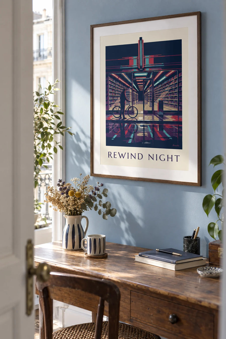 Poster of a video store and neon-lit shelves of VHS tapes at night: framed on the wall