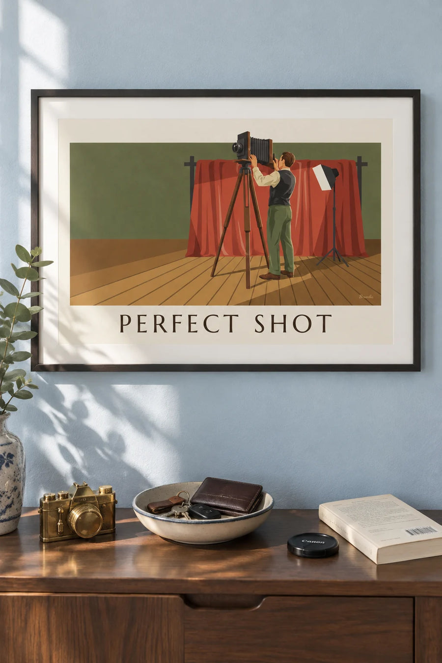 Poster of a photographer and bellows camera in a studio: framed on the wall